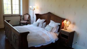 1 dormitorio con 1 cama grande con sábanas y almohadas blancas en Château De Werde, en Matzenheim