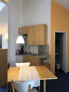 eine Küche mit einem Holztisch mit Stühlen und einer Tableasteryasteryasteryastery in der Unterkunft Apartmenthaus Somborn in Bochum