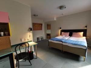 a bedroom with a bed and a desk with a tv at 2Home Hotel Gävle in Gävle