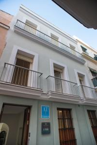 a white building with balconies on the side of it at La Posada del Mercado in Cádiz