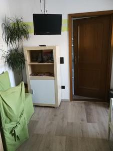 sala de estar con TV en la pared y puerta en Pension Harmonie, en Erfurt