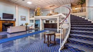 una escalera de caracol en el vestíbulo con una lámpara de araña en Best Western Riverside Inn, en Macon