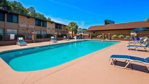una piscina con tumbonas y un hotel en Best Western Riverside Inn, en Macon