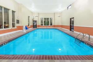een groot zwembad met blauw water in een gebouw bij Super 8 by Wyndham Pine Bluff in Pine Bluff