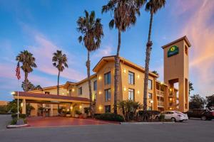 a hotel with palm trees in a parking lot at La Quinta Inn by Wyndham Ventura in Ventura