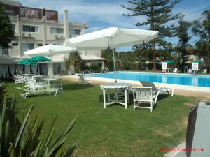 a group of chairs and umbrellas next to a pool at Hotel Puesta del Sol in Punta del Este