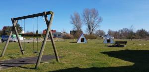 a playground with three tents and a swing at Ferienwohnung Sonne Nr_ 4 in Neddesitz