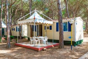 ein kleines gelbes Haus mit einem Tisch davor in der Unterkunft Camping Village Baia Blu La Tortuga in Aglientu