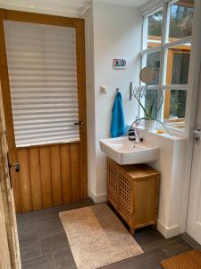 a bathroom with a sink and a window at Privé sauna & terras - Aachen Vaals Drielandenpunt in Vaals