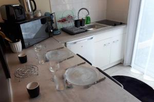 a kitchen counter with glasses and dishes on it at Maisonnette à 100 M de Tarbes sud in Laloubère +3 photos