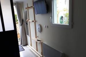 a room with a window and a clock on the wall at Maisonnette à 100 M de Tarbes sud in Laloubère