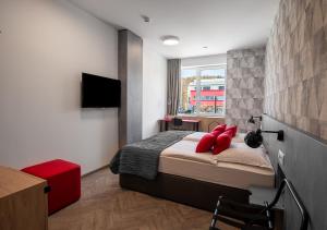リュブリャナにあるUrban Ring Hotelのベッドルーム(赤い枕のベッド1台、テレビ付) +37枚の写真