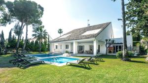 une maison avec une piscine dans la cour dans l'établissement Villa Marina, à Marbella