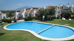 una gran piscina en el patio de una casa en Beautiful Town House With Air Conditioning In Secure Urbanisation. Internet., en Estepona