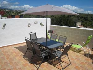 una mesa y sillas con una sombrilla en el patio en Beautiful Town House With Air Conditioning In Secure Urbanisation. Internet., en Estepona