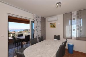 a dining room with a table and chairs and a balcony at Apartment Dora in Preko