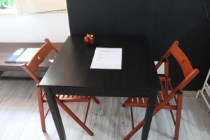 カターニアにあるLittle Sicilyの黒いテーブル(椅子2脚付)と紙
