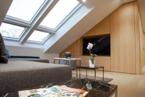 ein Wohnzimmer mit einem Bett und einem TV in der Unterkunft Toploft Serviced Apartments in Crailsheim