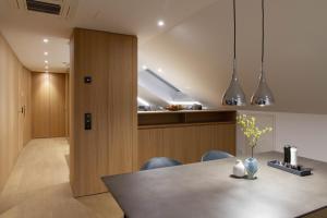 Toploft Serviced Apartments في كرايلسهايم: مطبخ وغرفة طعام مع طاولة وكراسي
