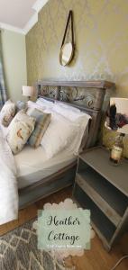 1 dormitorio con cama y espejo en la pared en Heather Cottage Aberdeen en Aberdeen