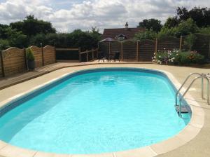 a large blue swimming pool in a yard at Whimple Cottage in Exeter