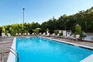 uma grande piscina com cadeiras e uma cerca em Holiday Inn Express Jasper, an IHG Hotel em Jasper
