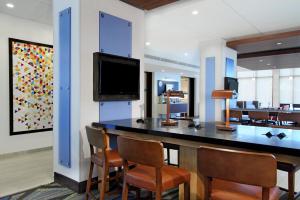 um átrio com um bar com cadeiras e uma televisão de ecrã plano em Holiday Inn Express Jasper, an IHG Hotel em Jasper