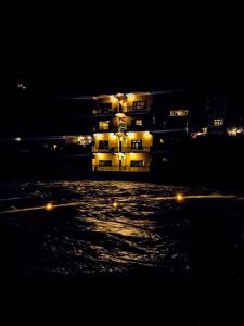 een verlicht gebouw in het water 's nachts bij Hotel Lords Palace Kalam in Kārandūkai