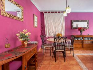 テヒーナにあるHoliday Home La Marea by Interhomeのピンクの壁のダイニングルーム(テーブル、椅子付)