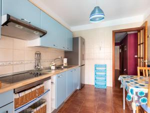 テヒーナにあるHoliday Home La Marea by Interhomeの青いキャビネットとテーブル付きのキッチン