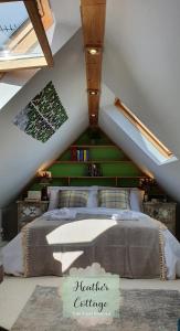 een slaapkamer met een bed met een groene accentmuur bij Heather Cottage Aberdeen in Aberdeen