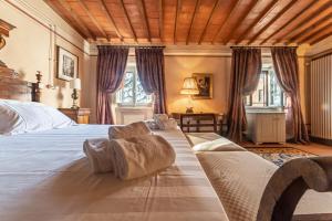 - une chambre avec un grand lit et un plafond en bois dans l'établissement Palazzo Nobile di San Donato, à Montepulciano