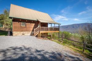 ein Blockhaus mit einer Terrasse und einem Zaun in der Unterkunft A View to Remember in Sevierville