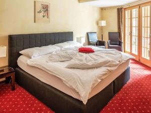 Cama grande en habitación con alfombra roja en Apartment Chalet Smaragd-3 by Interhome, en Grindelwald