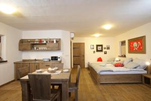 1 dormitorio con cama, mesa y cocina en Panonska Vas Apartments en Moravske-Toplice