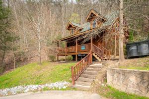 a log cabin in the woods with stairs leading to it at Bear Naked in Cove Creek Cascades