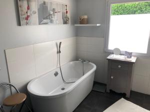 a white bath tub in a bathroom with a window at Maison au cœur du circuit des 24 heures du Mans in Le Mans