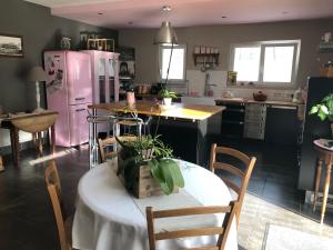 a kitchen with a table and a pink refrigerator at Maison au cœur du circuit des 24 heures du Mans in Le Mans +10 photos