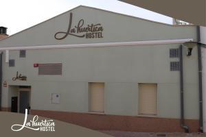 un edificio blanco con el nombre de una institución de enfermería en Hostel La Huertica, en Valtierra