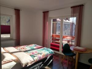 a bedroom with a bed and a table and a window at Willa Relaks in Lądek-Zdrój