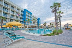 a pool at a resort with chairs and palm trees at Holiday Inn Resort Fort Walton Beach by IHG in Fort Walton Beach