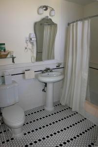 a white bathroom with a toilet and a sink at El Tovar - Inside the Park in Grand Canyon Village +52 photos