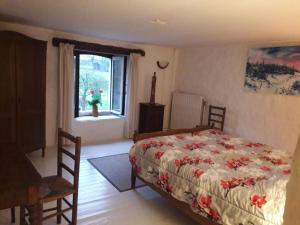 1 dormitorio con cama y ventana en Beautiful and Authentic Cottage, en Houffalize