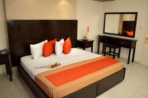 - une chambre avec un grand lit, un miroir et un piano dans l'établissement Hotel Elizabeth Ciudad Deportiva, à Aguascalientes
