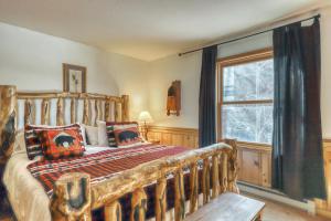 a bedroom with a wooden bed and a window at Snowfire in Angel Fire