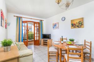 ein Wohnzimmer mit einem Sofa und einem Tisch in der Unterkunft Apartamento Els Girasols in Son Bou