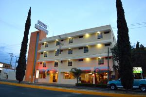 un edificio con un camión azul estacionado frente a él en Hotel Elizabeth Ciudad Deportiva, en Aguascalientes