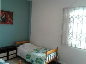 a small bedroom with a bed and a window at Pousada do Parque in Porto Alegre