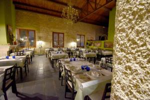 un comedor con mesas y sillas blancas en HOTEL RURAL A VELHA FABRICA, en Valverde del Fresno