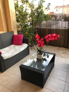 a patio with a couch and a table with red flowers at Mandria Retreat in Mandria